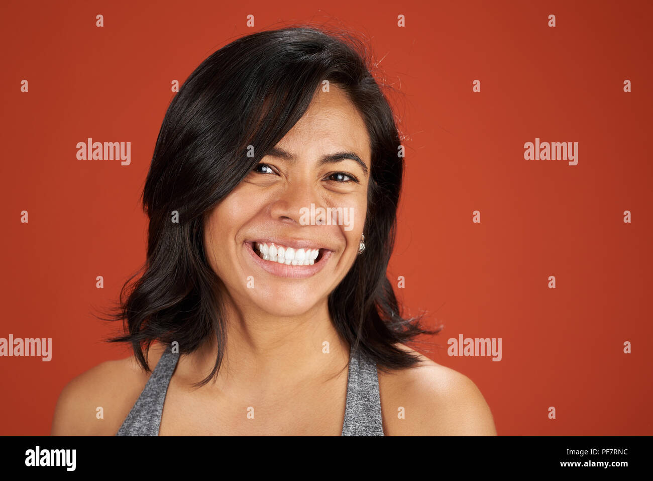 Latina Happy smiling young woman portrait couleur orange sur fond de studio Banque D'Images