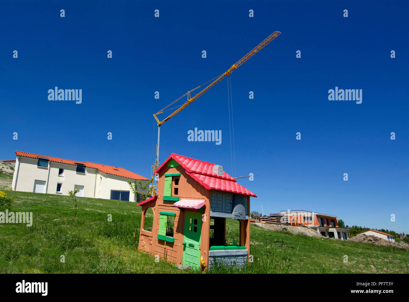 La maison des enfants en plastique sur un terrain avec une grue et maisons en construction, France Banque D'Images