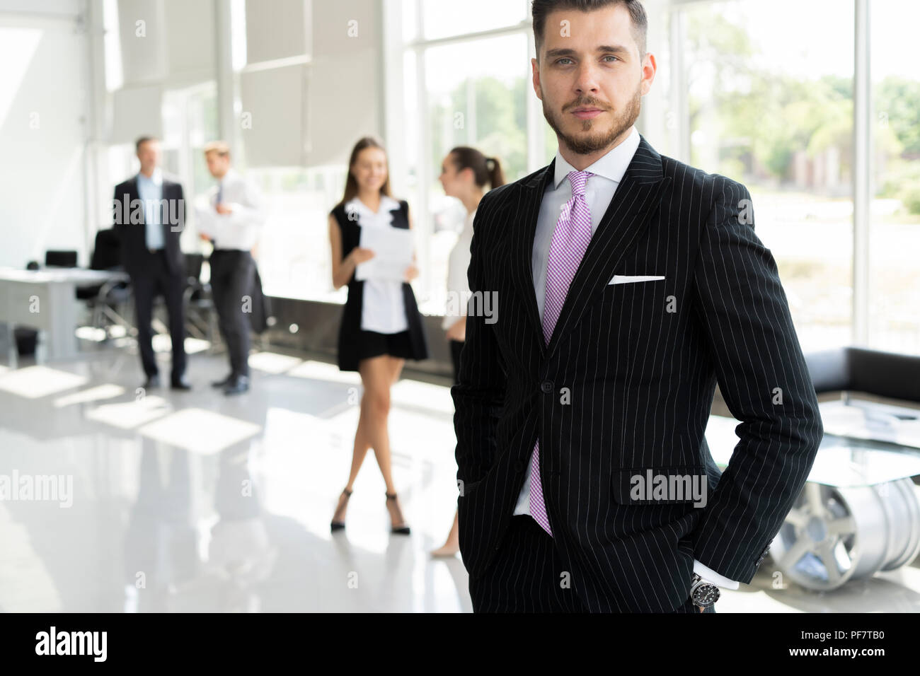 Heureux l'homme d'affaires à puce avec l'équipe de discuter à l'arrière-plan. Banque D'Images