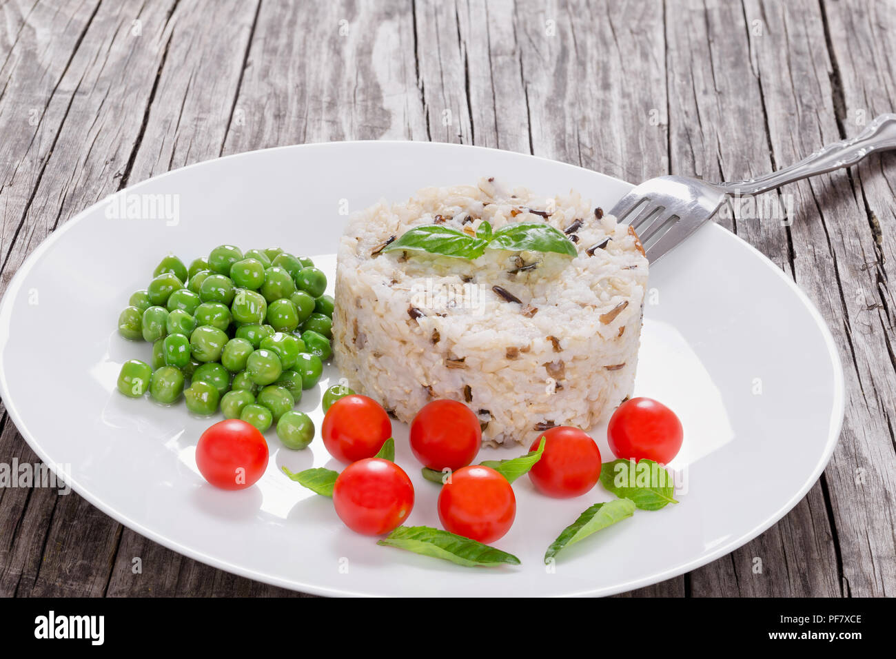 Le riz brun et le riz sauvage avec des tomates cerises, petits pois Banque D'Images