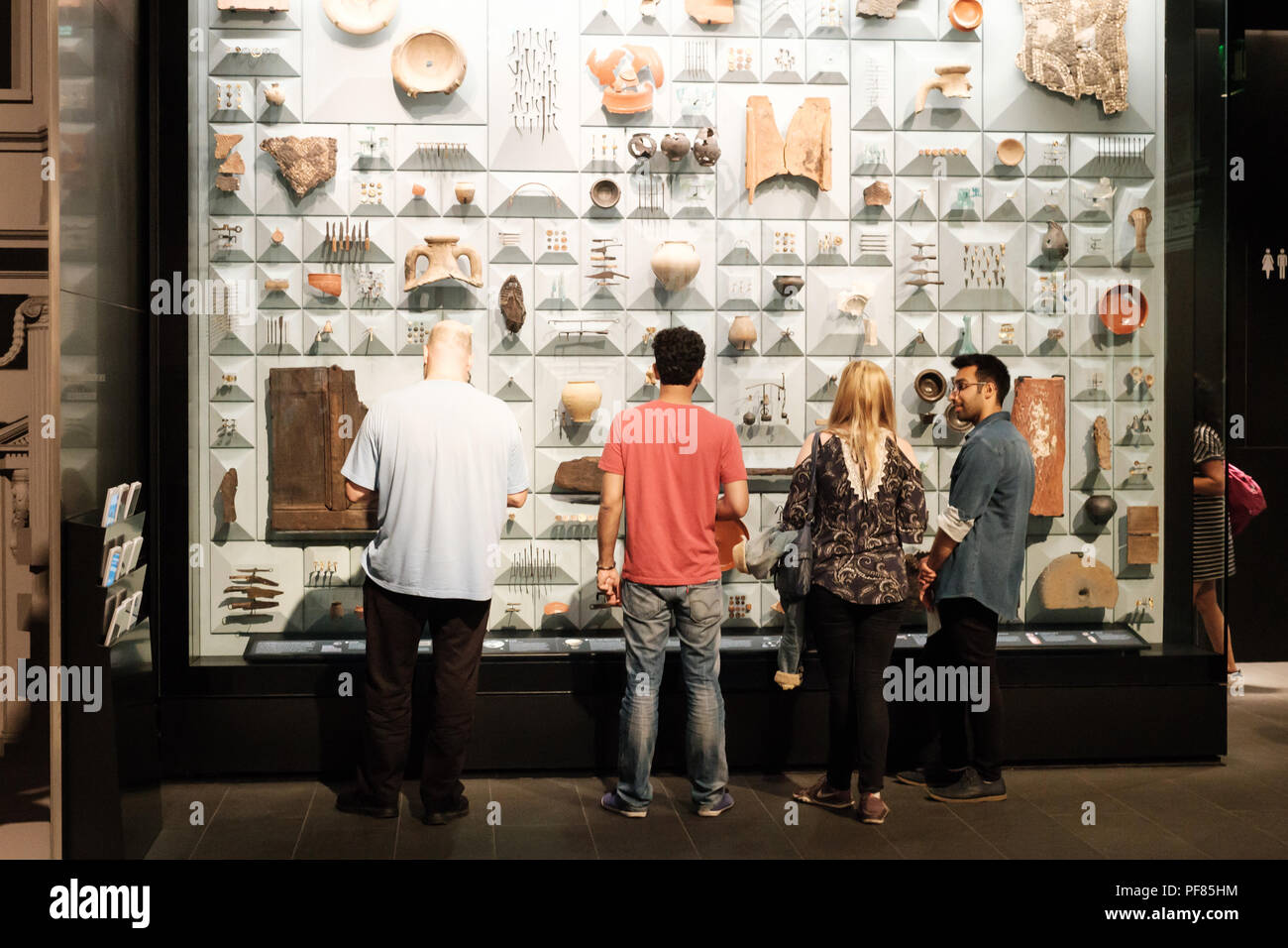 Les visiteurs d'examiner un cas d'affichage d'objets romains trouvés au cours de la restauration du Temple de Mithra Mithraeum, London, City of London Banque D'Images