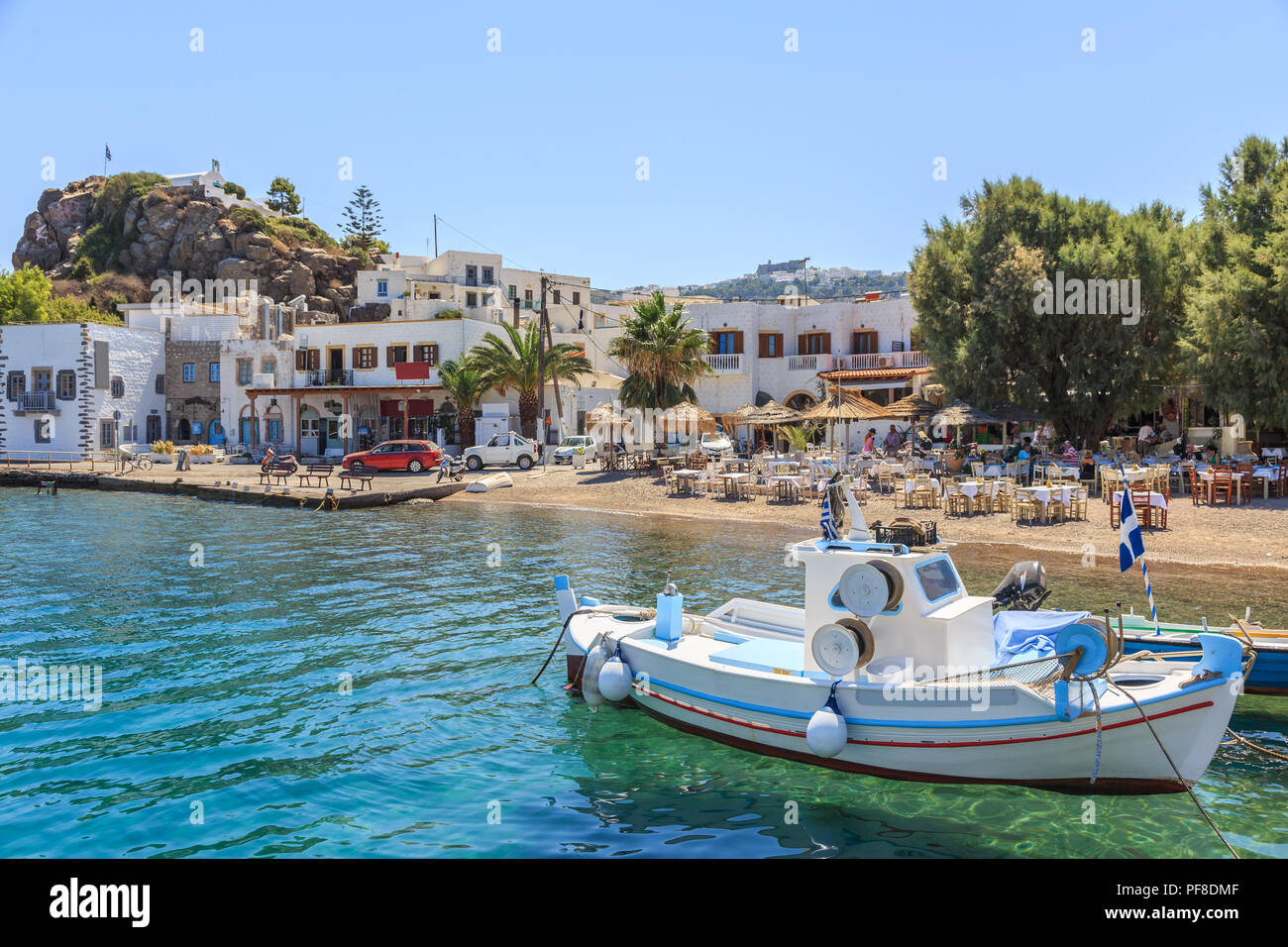 L'île grecque de Patmos appartient à l'archipel du Dodécanèse. Fragment du port de pêche et de plage dans la ville de Skala. Sur la colline de la ville visible Chora et Mona Banque D'Images