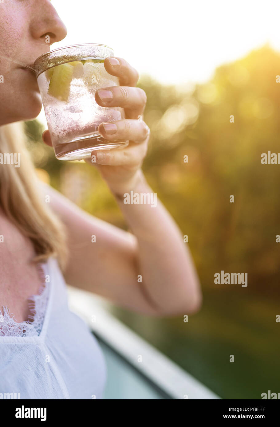 Femme blonde à l'extérieur de boire boisson glacée Banque D'Images