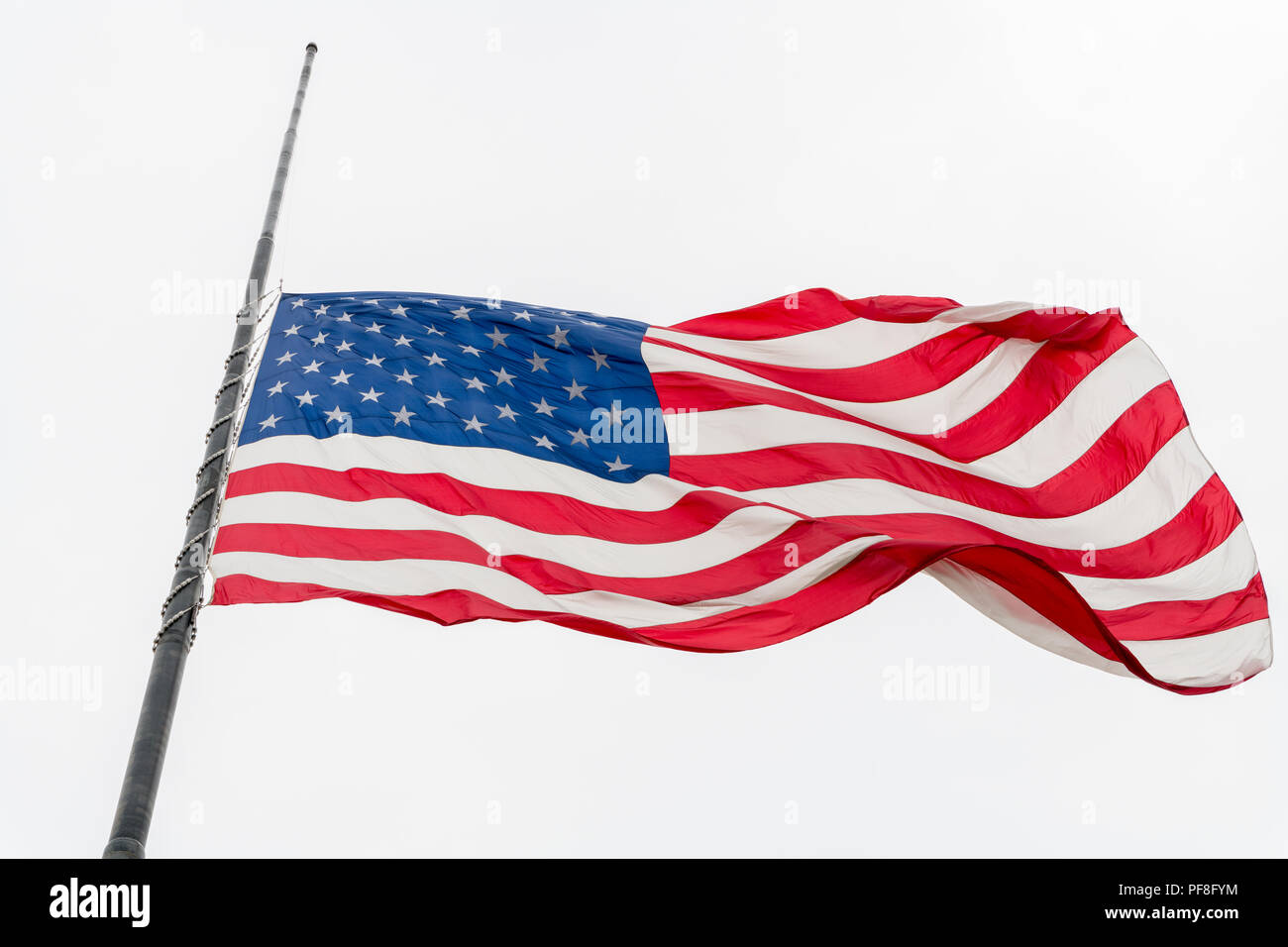 United States flag flying à demi-personnel forme contre ciel gris Banque D'Images