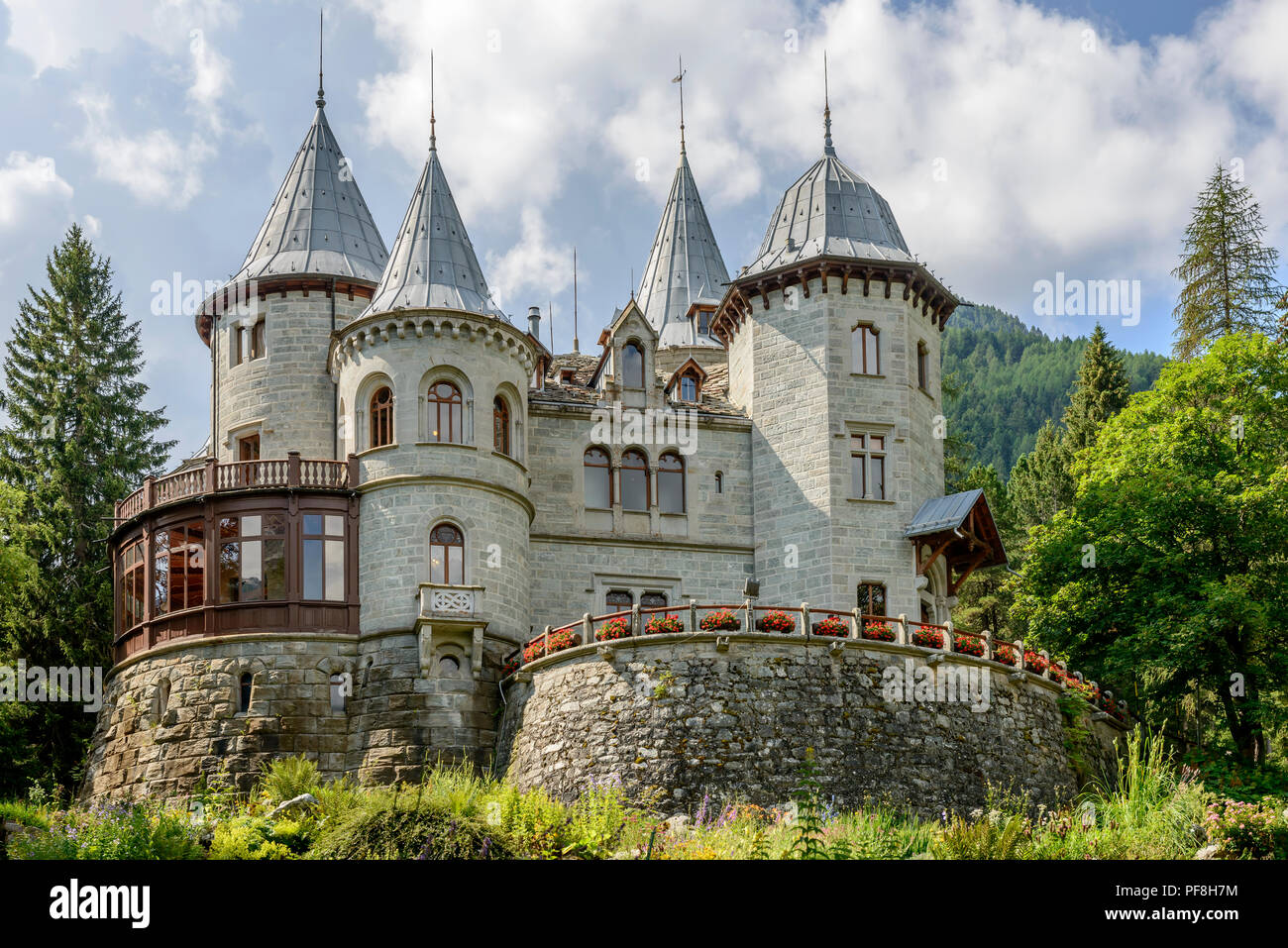 Vue sur Château Savoia entre les sapins, tourné par un beau jour d'été à Gressoney Saint Jean, vallée du Lys, Aoste, Italie Banque D'Images
