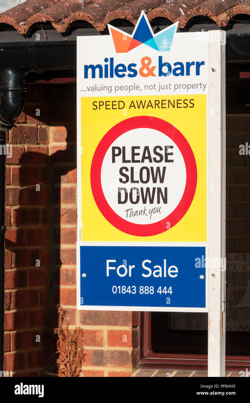 Sensibilisation vitesse Ralentissez message incorporé dans un agent immobilier à vendre du conseil. Banque D'Images