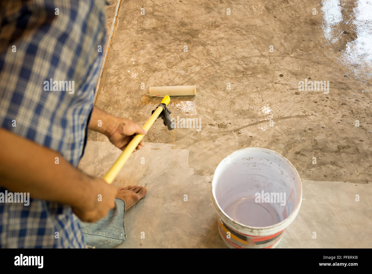 Travailler les sols en béton à l'aide de laquage pour revêtement de rouleau Banque D'Images