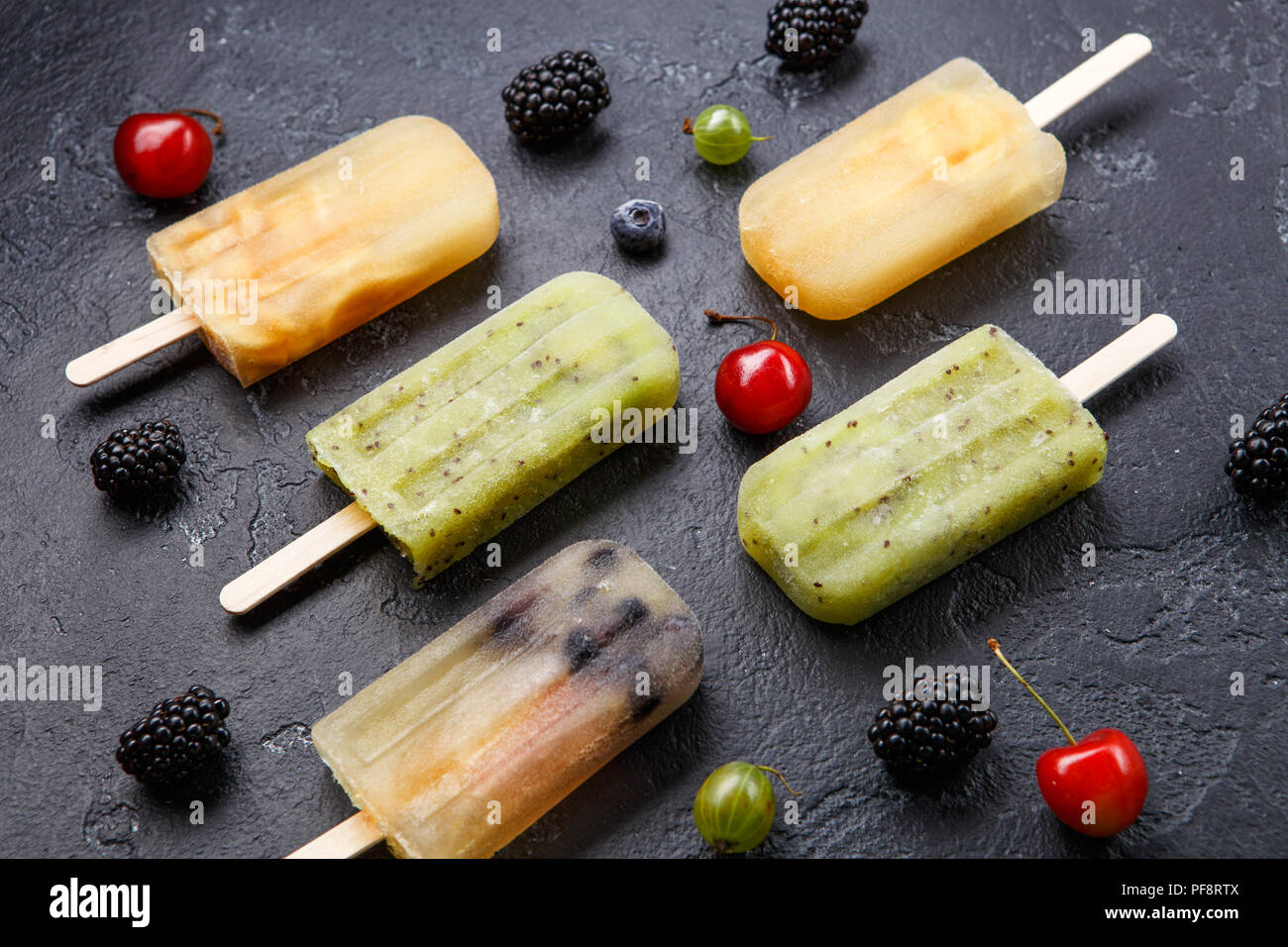 Photo de jus de fruits surgelé sur des bâtons et les baies Banque D'Images