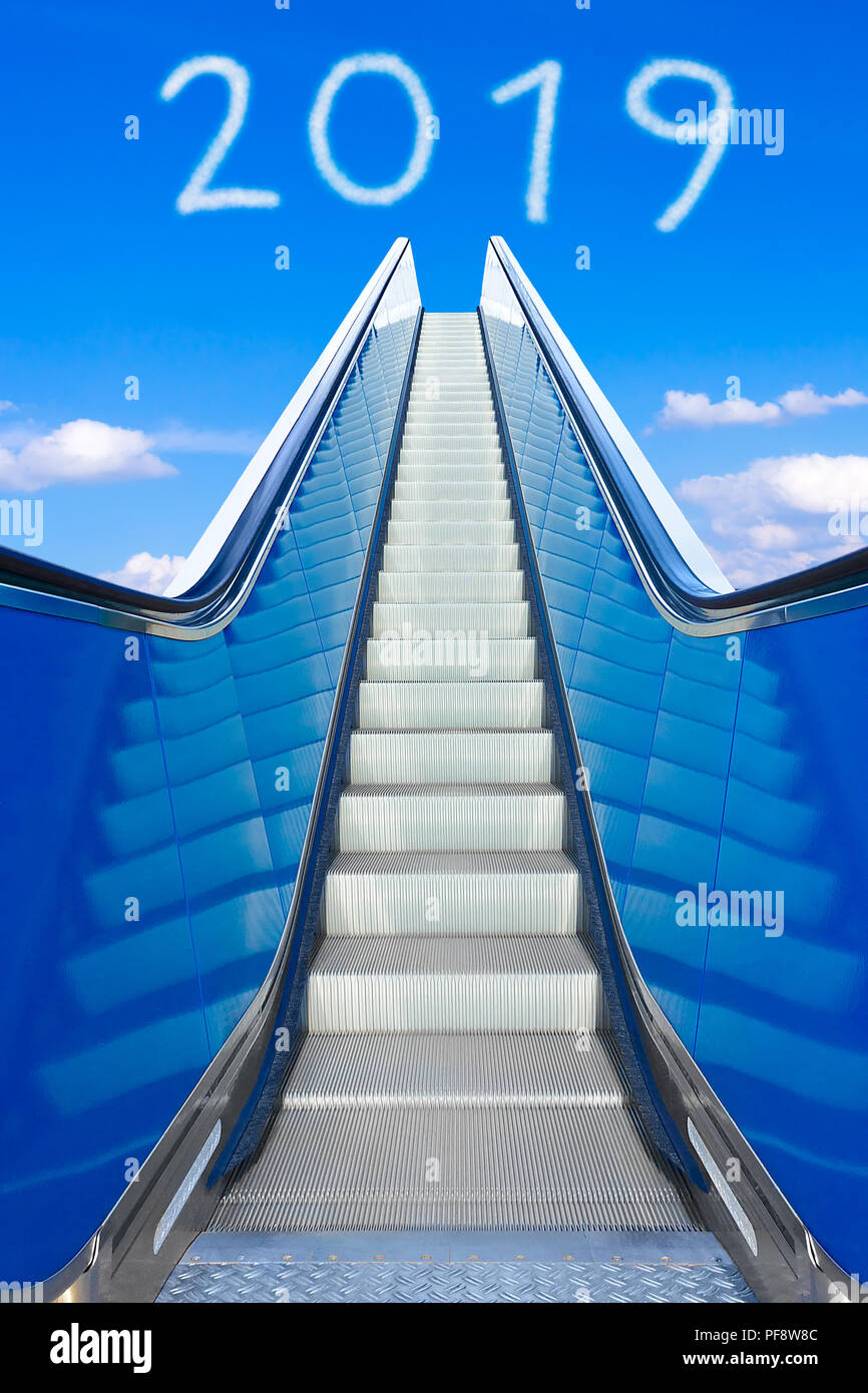 D'atteindre la nouvelle année 2019 sur un escalier ou un escalier mécanique en mouvement dans un ciel bleu clair. Photo Concept de succès et d'atteindre des objectifs sur une surface lisse et facile Banque D'Images