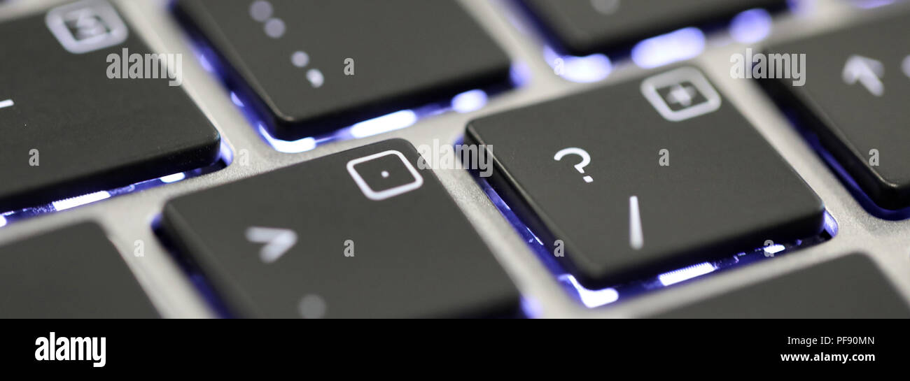 Gros plan du point d'interrogation caractère spécial sur un clavier illuminé sur un ordinateur portable ou ordinateur. Banque D'Images