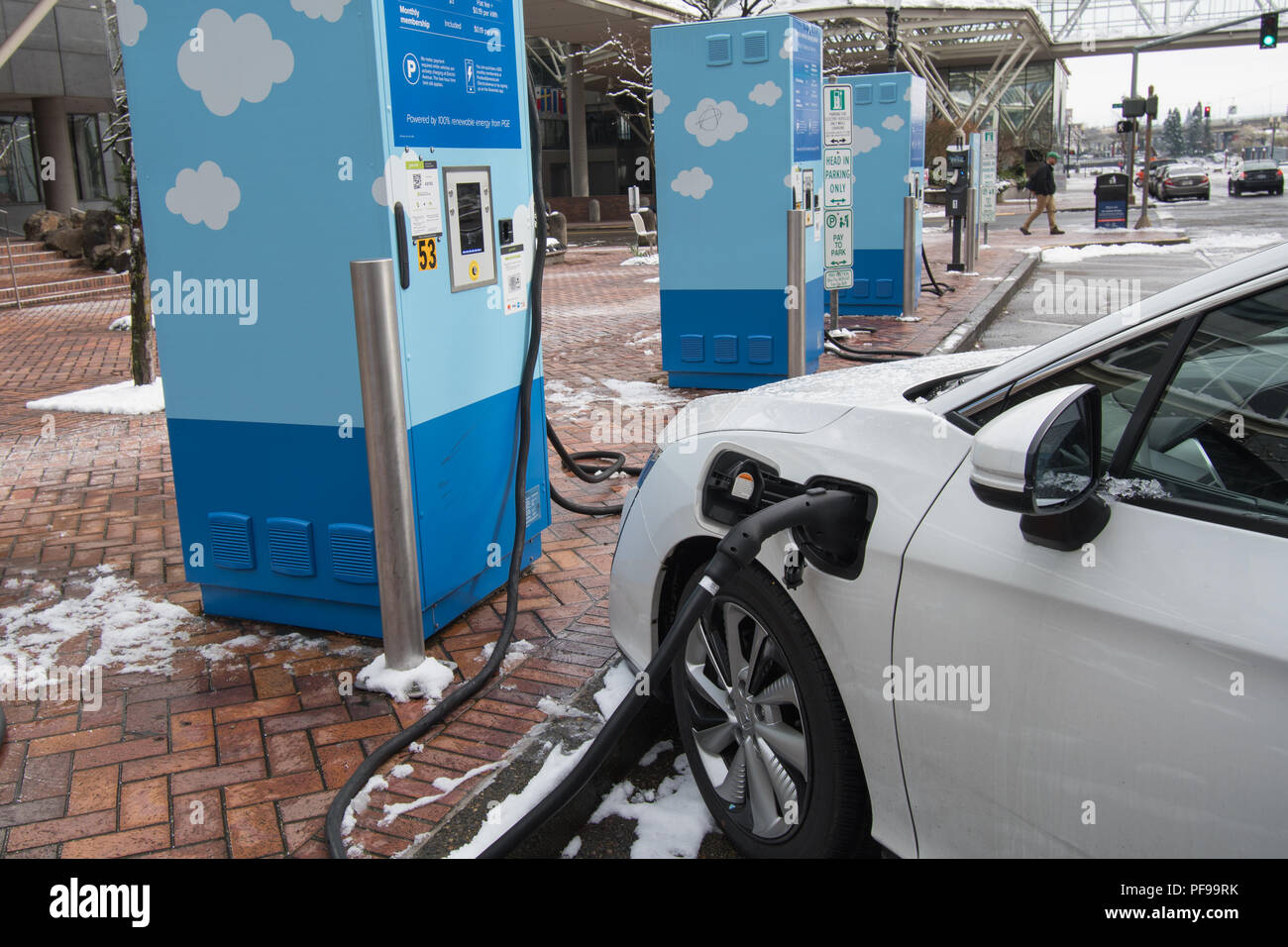 PORTLAND, OREGON, le 21 février 2018 : une voiture Honda branché à une station de charge électrique avec plaques de neige sur le terrain. Banque D'Images