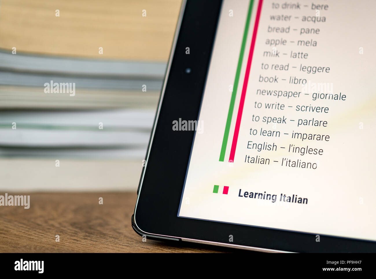 Apprendre l'italien à l'aide d'une tablette avec des livres dans l'arrière-plan. Banque D'Images