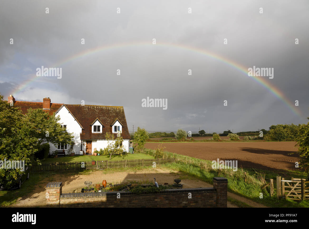 Buckingham, Royaume-Uni - le 11 septembre 2017. Une maison traditionnelle anglaise est encadrée par un arc-en-ciel sur campagne dans le Buckinghamshire, Royaume-Uni Banque D'Images