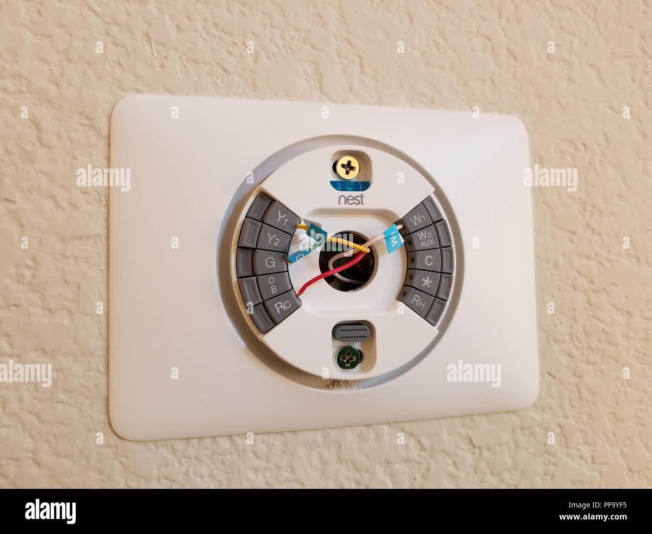 Installation d'un nid de Thermostat Apprentissage Google Inc, montrant les fils basse tension inséré dans la plaque arrière du thermostat, en banlieue, à la maison de San Ramon, Californie, le 4 mai 2018. () Banque D'Images