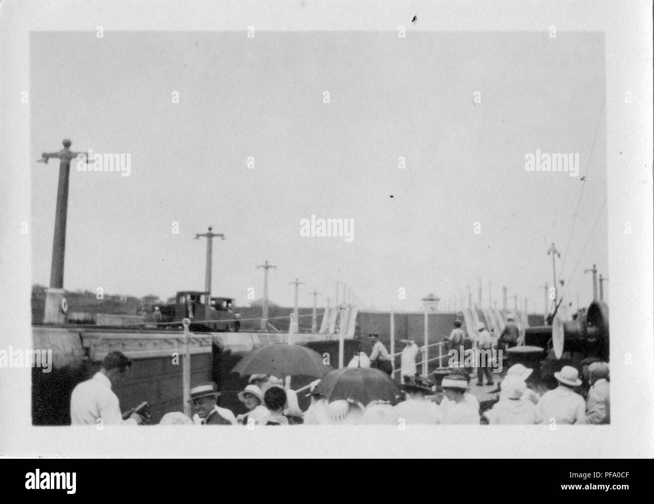 Photographie noir et blanc, montrant les gens sur le pont d'un navire qui est à l'intérieur ou de l'ouverture d'un blocage du canal de Panama, avec poteaux d'éclairage électrique, les voies de chemin de fer, et des véhicules ferroviaires visible sur les banques, et d'un verrou dans la tour de contrôle de la distance, 1915. () Banque D'Images