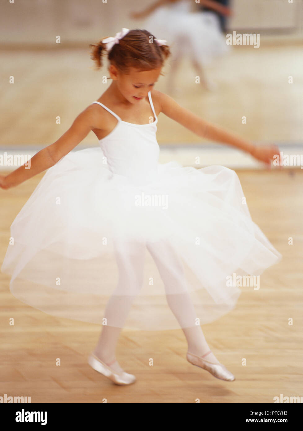 Ballerine jeune danseur vêtu de blanc et long tutu marcher gracieusement Banque D'Images