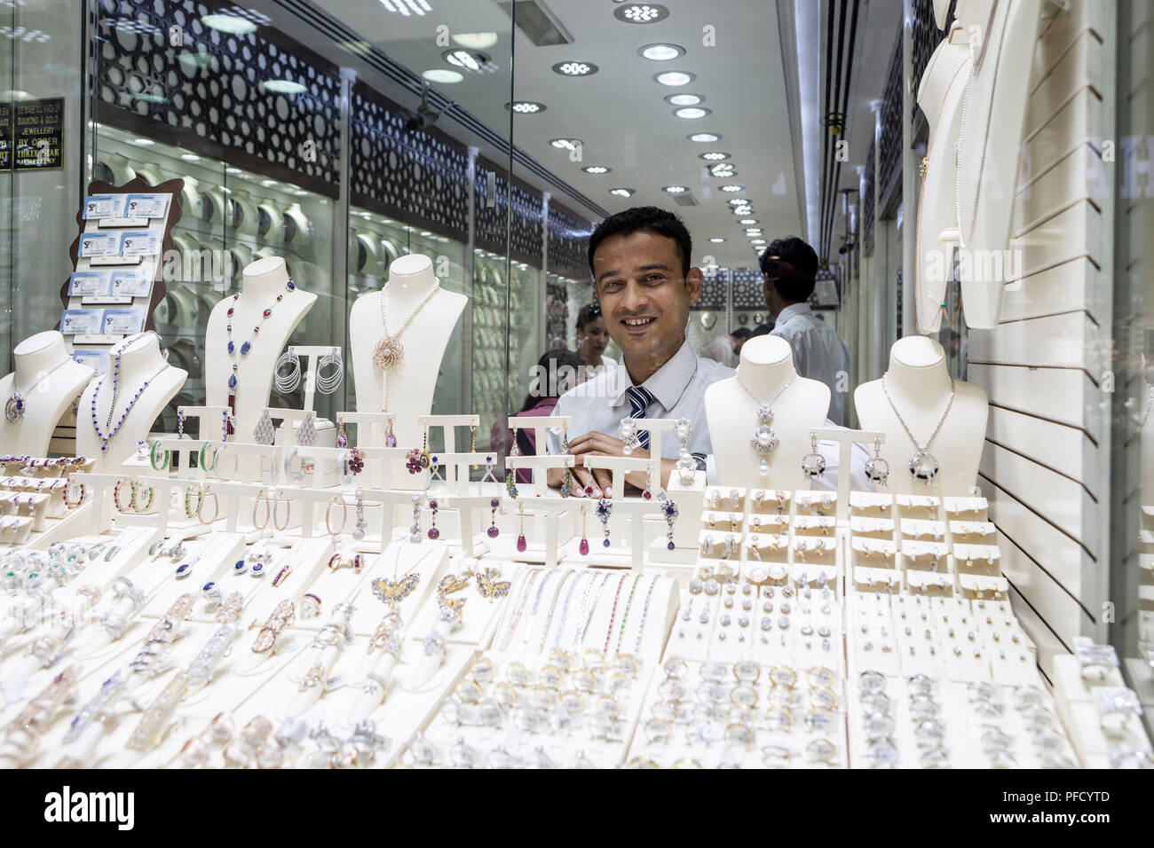 Vendeur vue à travers une vitrine derrière un écran d'or et des bijoux à la Gold Souk de Deira à Dubaï, Émirats arabes unis Banque D'Images