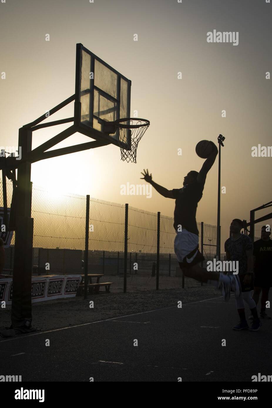 Un membre de service pour le géant la jante en remplissant un slam dunk avant un match exhibition au Camp Arifjan, au Koweït, le 7 juin 2018. Le jeu, qui a été entraîné par une légende WNBA Ruthie Bolton, et NBA legends Kevin Martin et Monty Williams, a fait partie de la NBA Cares Hoops pour les troupes d'. Les cerceaux pour les troupes est une initiative dirigée par la NBA en collaboration avec le ministère de la défense, de l'usage et d'autres militaires et des organismes au service des anciens combattants à l'honneur de service actifs et à la retraite, hommes et femmes, et leurs familles. Banque D'Images