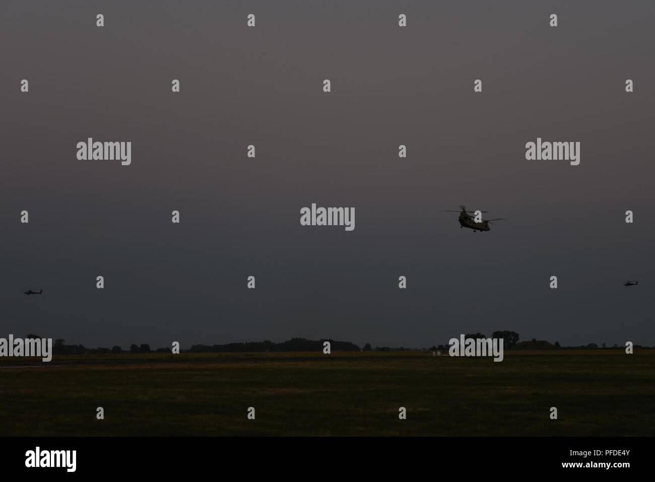 AH-64 Apache et CH-47 Chinook assigné à la Force Viper 1er Bataillon, 3e Régiment d'aviation, 12e Brigade d'aviation de combat Mener des opérations de nuit à l'aérodrome militaire à Inowroclaw, Pologne pendant la grève 18 Sabre, le 4 juin 2018. Grève de sabre 18 facilite la coopération entre les États-Unis, l'estonien, letton, lituanien, polonais et d'autres pays alliés et les pays partenaires à améliorer la capacité opérationnelle dans une variété de missions. L'exercice prépare les nations participantes et de ses unités pour des opérations futures, tout en renforçant l'alliance de l'OTAN. L'exercice de cette année prévoit 18, Banque D'Images