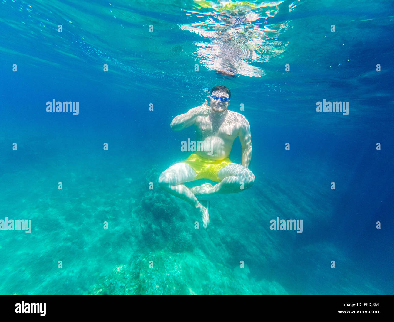 L'homme nage sous l'eau avec des verres sous-marine vacances d'été. Banque D'Images
