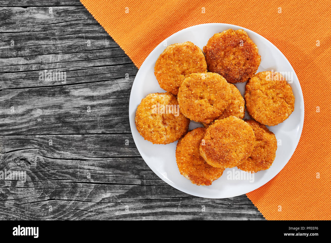 Escalopes de Viande panée délicieuse juteuse sur le plat blanc sur de vieilles planches de bois sombre, vue d'en haut Banque D'Images