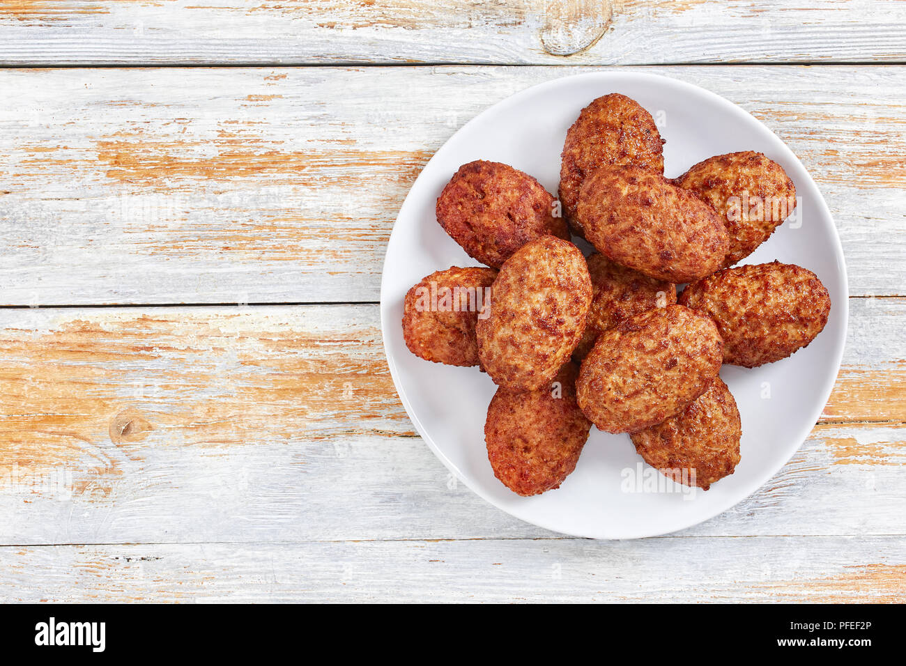Escalopes de délicieux plats de viande juteuse sur plaque blanche sur de vieilles cartes de la peinture rustique, vue d'en haut Banque D'Images