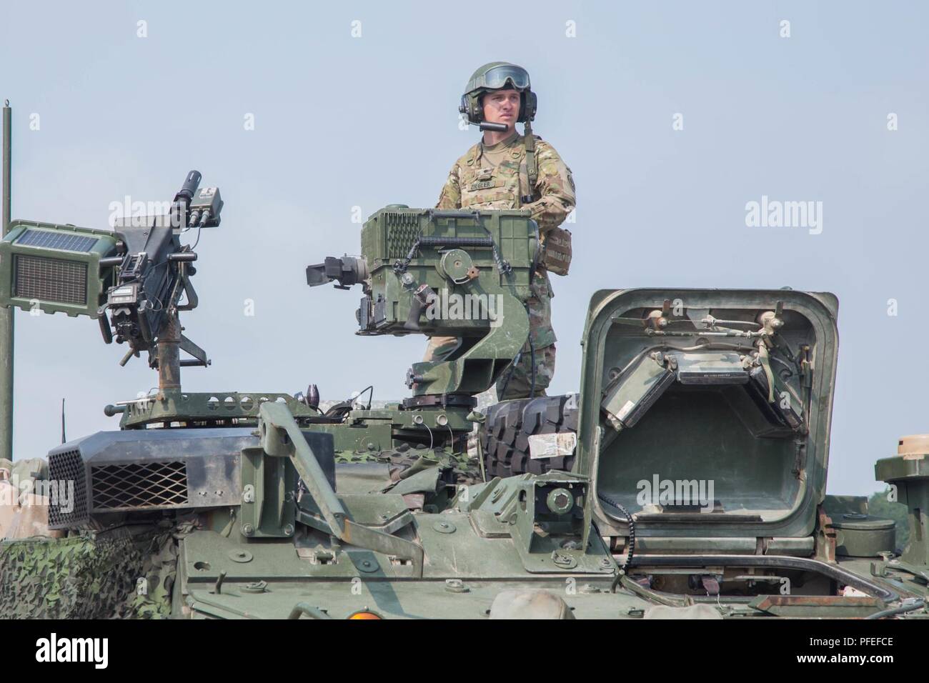 La CPS de l'armée américaine. Ziegler, 2e Escadron, 2e régiment de cavalerie, se dresse au sommet d'un véhicule blindé Stryker à ravitailler un site au cours d'un convoi en direction de la zone d'entraînement Bemowo Piskie, Pologne pour le sabre grève 18 Juin, 2018, 3. Grève 18 Sabre est une Europe de l'armée américaine a conduit à la formation coopérative exercice visant à améliorer l'interopérabilité interarmées à l'appui d'opérations multinationales. Banque D'Images