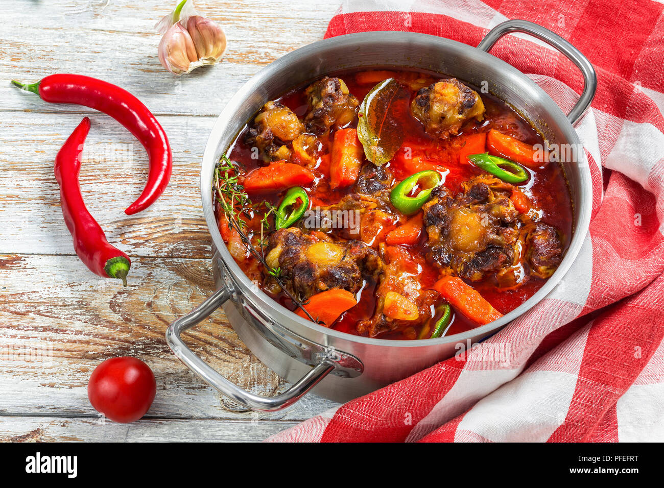 Rabo de Toro ou ragoût de bœuf soupe dans casserole avec le piment, l'ail et le thym. cuisine serviettes sur la vieille table en bois blanc, l'Espagne traditionnelle cuisi Banque D'Images