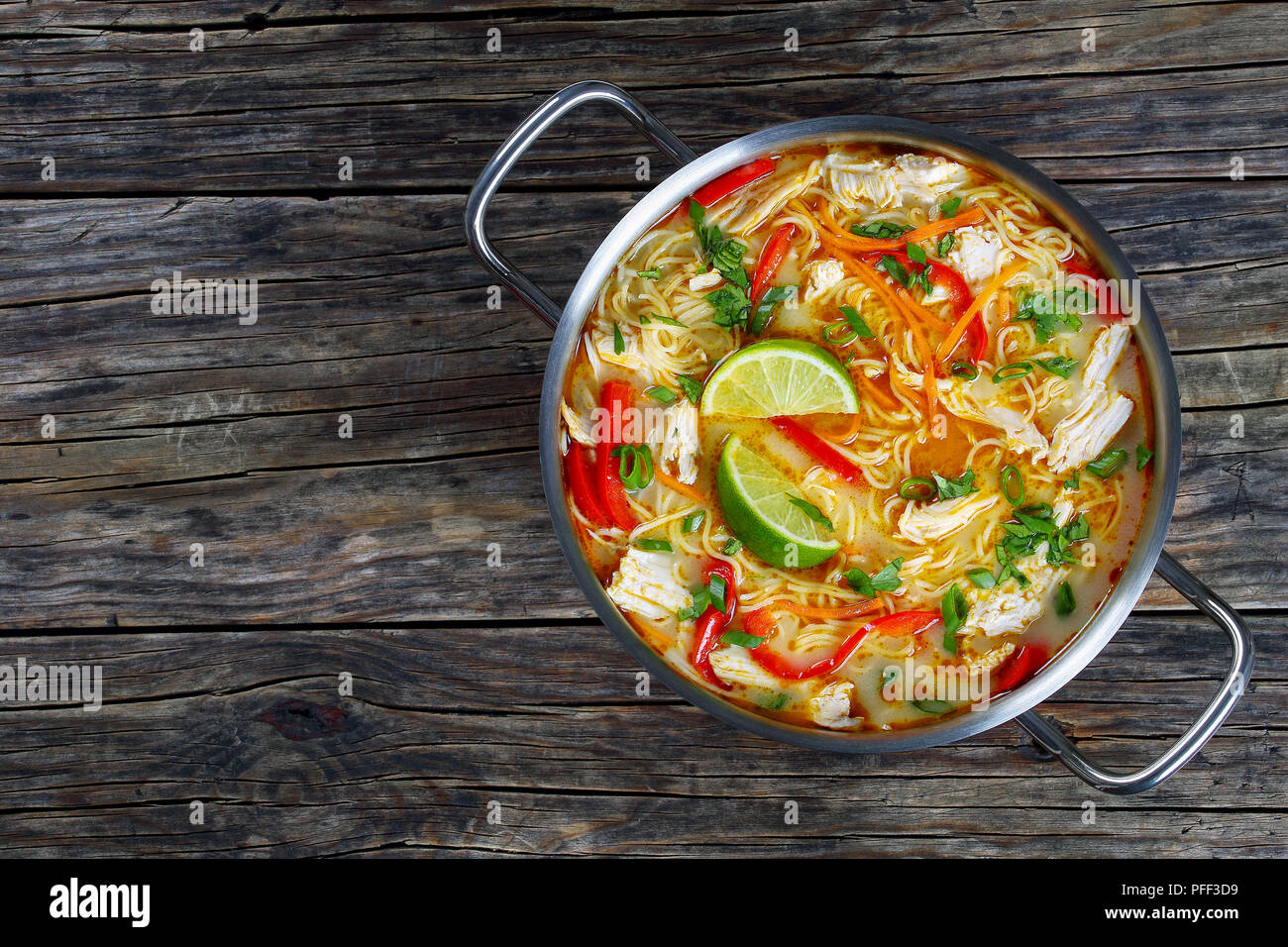 Délicieux et citron soupe poulet et nouilles en casserole sur la vieille table en bois foncé, traditionnelle recette classique, vue d'en haut Banque D'Images