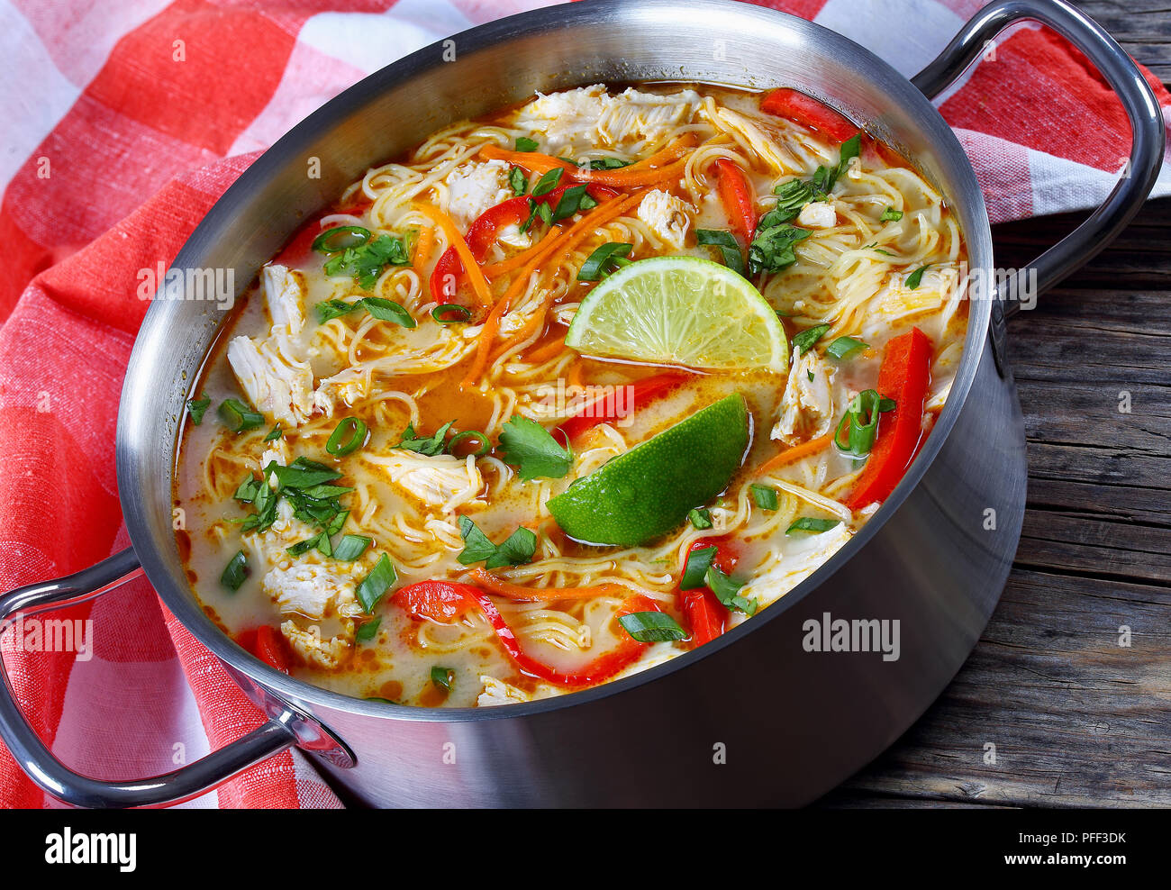 Délicieux et épicé de poulet thaï au curry vert au lait de coco dans la casserole sur la vieille table en bois foncé avec une serviette de cuisine traditionnelle, cla Banque D'Images