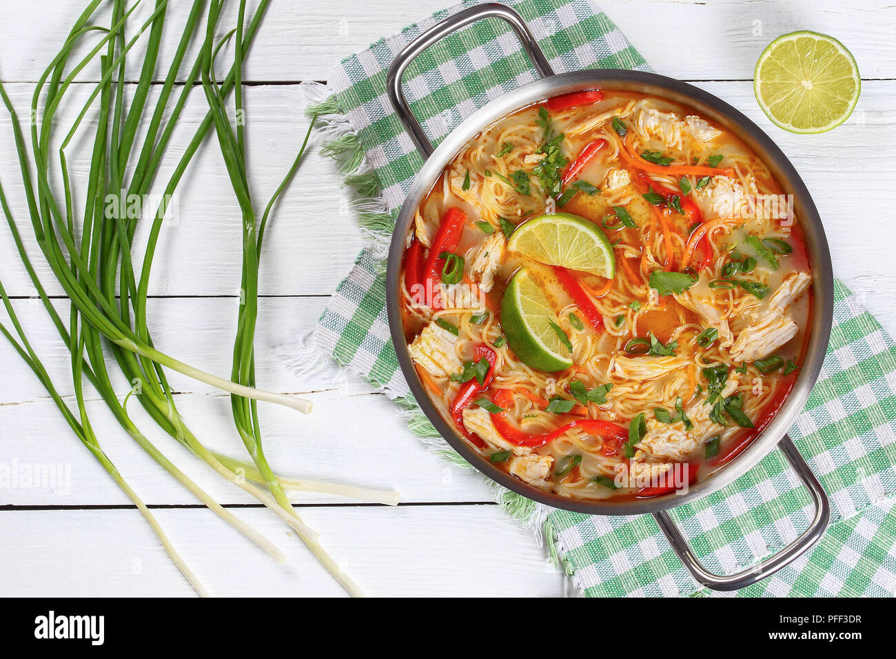 Délicieux et épicé de poulet thaï au curry vert soupe de nouilles en casserole sur la table en bois avec des serviettes de cuisine traditionnelle, recette classique, vue d'abo Banque D'Images