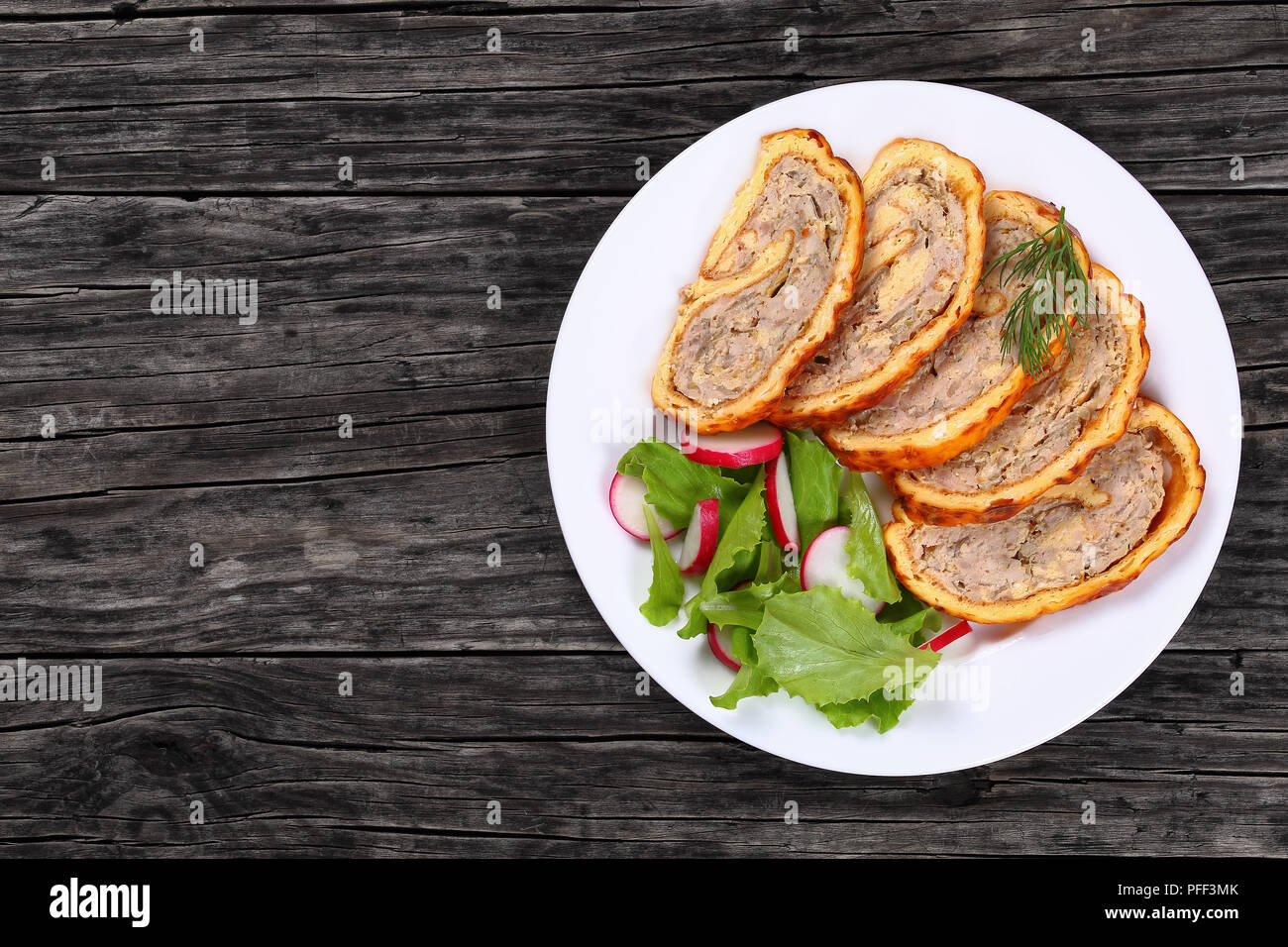 De délicieux champignons poulet épicé de viande roll-up à golden croûte de  fromage coupé en tranches et radis salade de laitue fraîche sur plaque  blanche sur noir w Photo Stock - Alamy