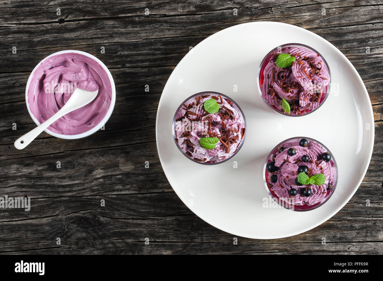 Délicieux dessert d'été sain de cassis décoré de feuilles de menthe dans le verre tasses sur la plaque. Crème fouettée surgelée yogourt dans un bol la ricotta mousse Banque D'Images