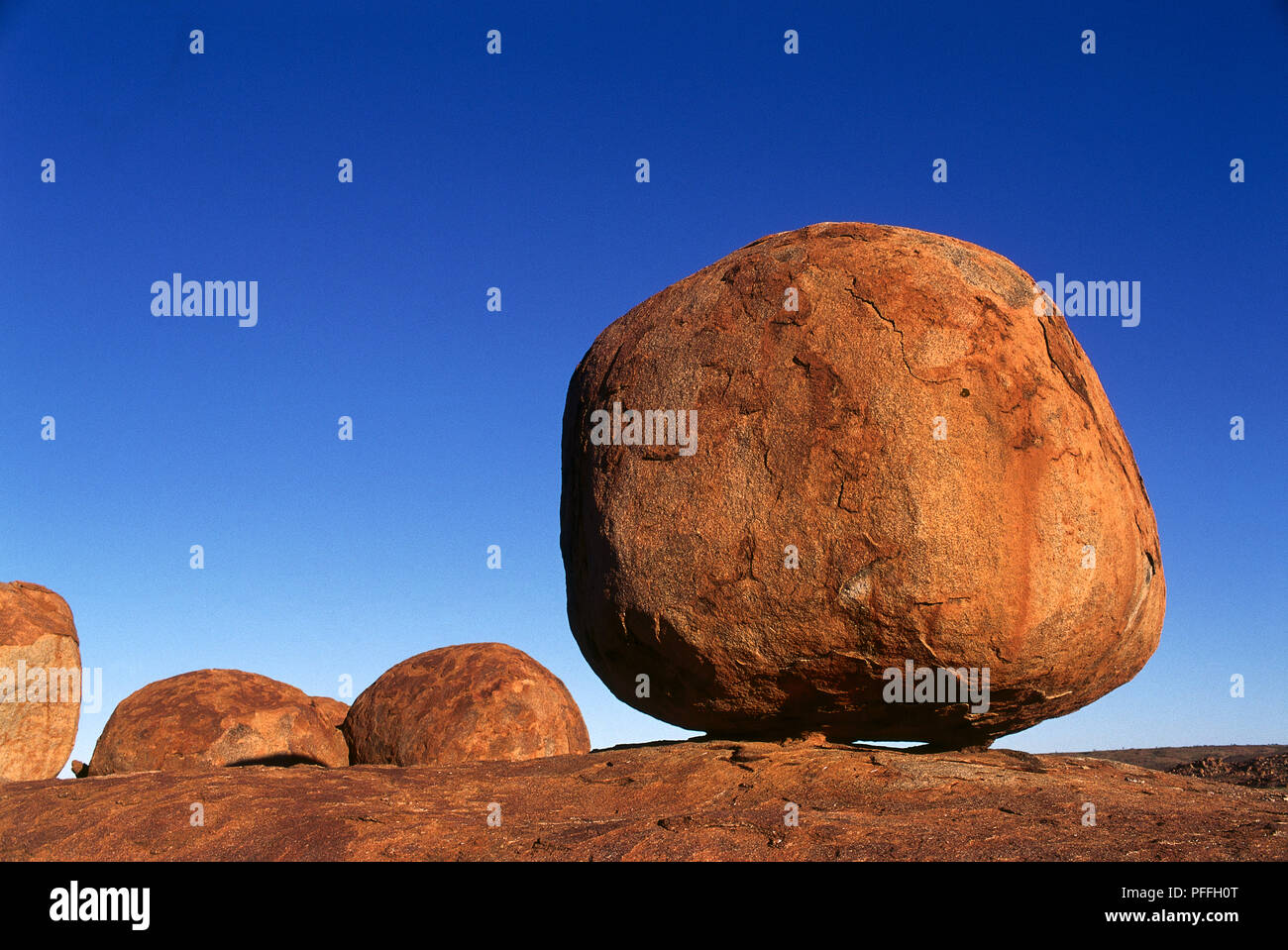 L'Australie, Territoire du Nord, Devil's Marbles gros rochers de granit en télévision désert de sable contre ciel bleu Banque D'Images