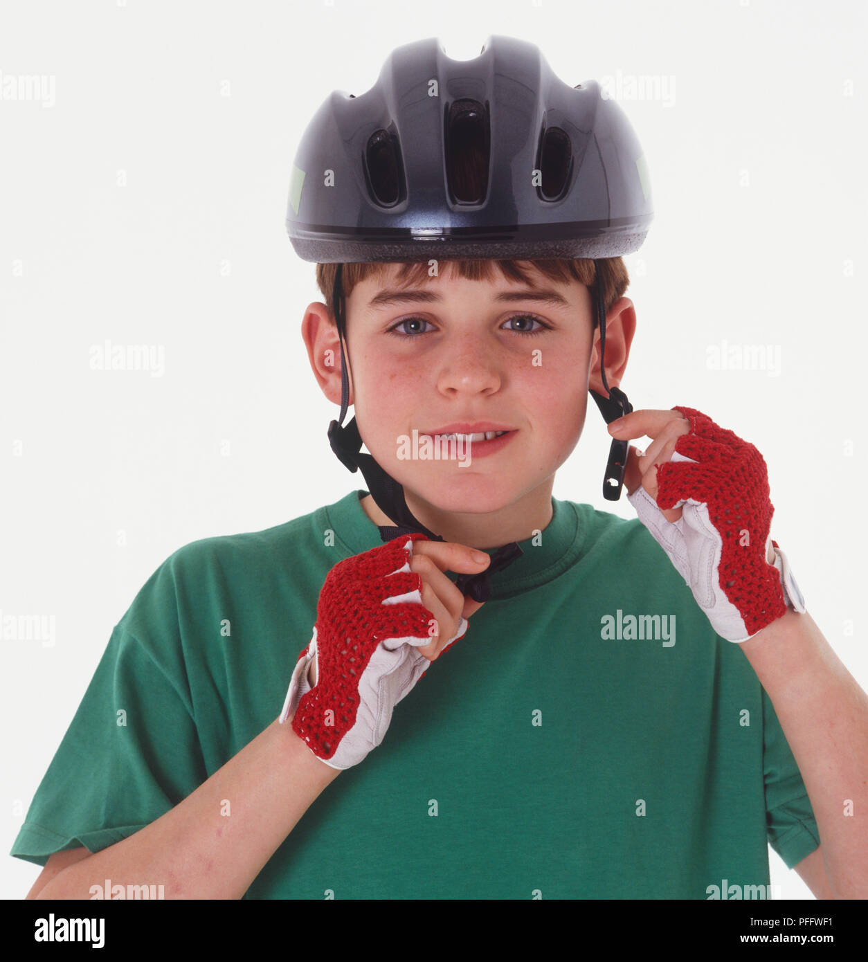 Boy putting sur un casque de vélo, vue avant Banque D'Images
