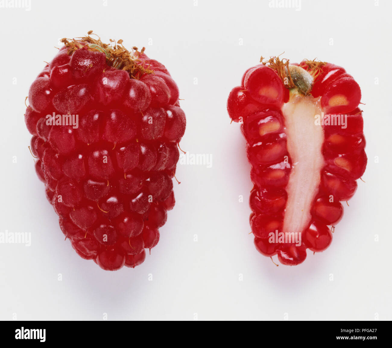 Toute une framboise à côté d'une coupe d'une framboise. Banque D'Images