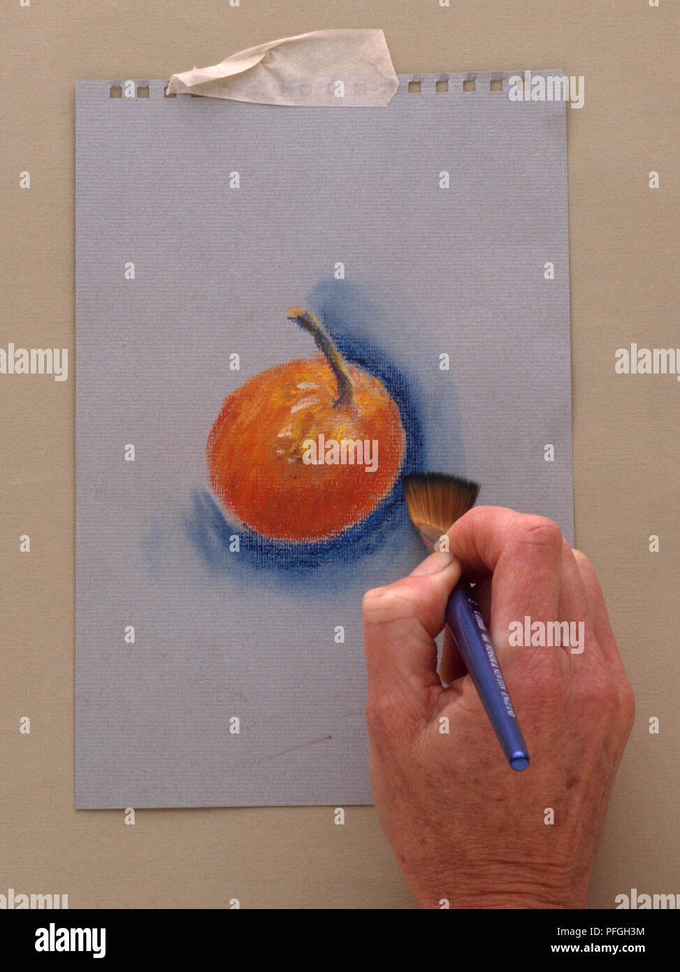 Woman's hand en utilisant le pinceau pour mélanger des couleurs pastel sur la peinture d'une pomme, close-up Banque D'Images