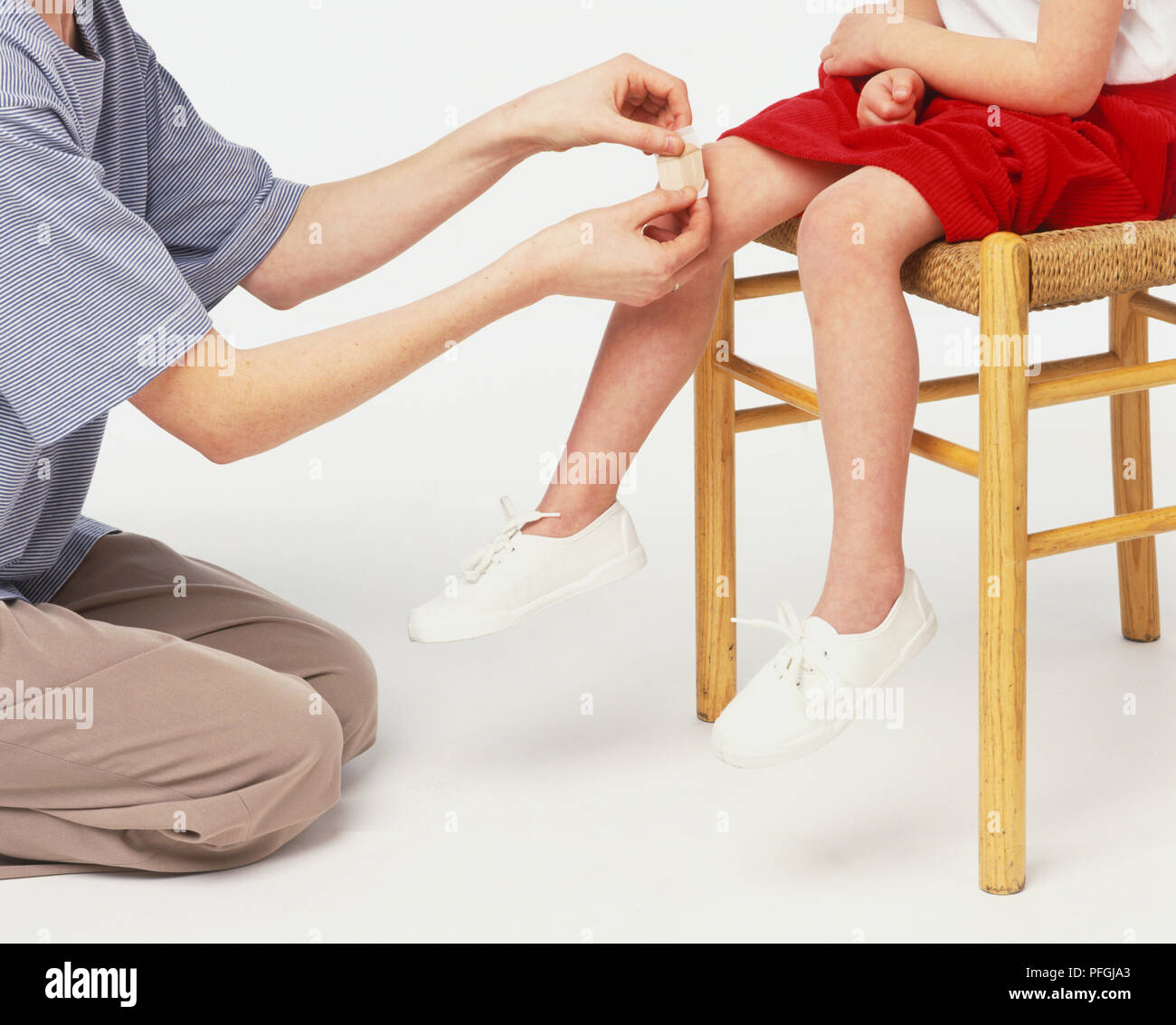 Coller un plâtre sur adultes girl's knee, Close up. Banque D'Images
