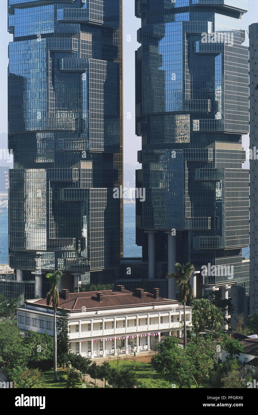 La Chine, Hong Kong, deux tours octogonales du Lippo Centre habillé de verre réfléchissant, et une plus petite maison devant la mer, creux visible écart entre towers Banque D'Images