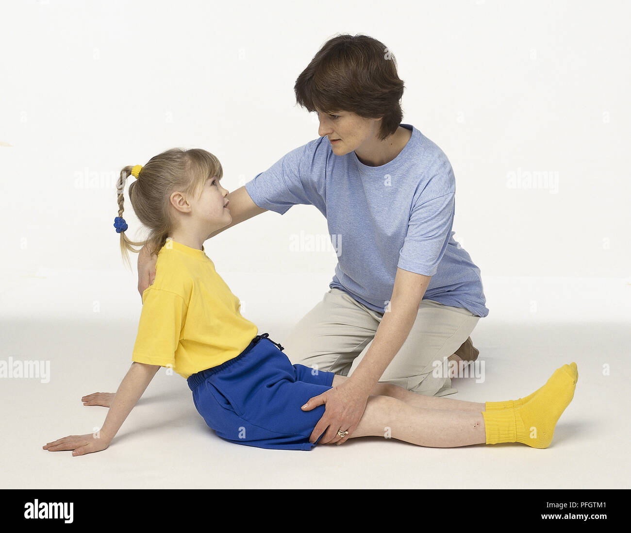 Femme enfant assis sur sol rassurant. Banque D'Images