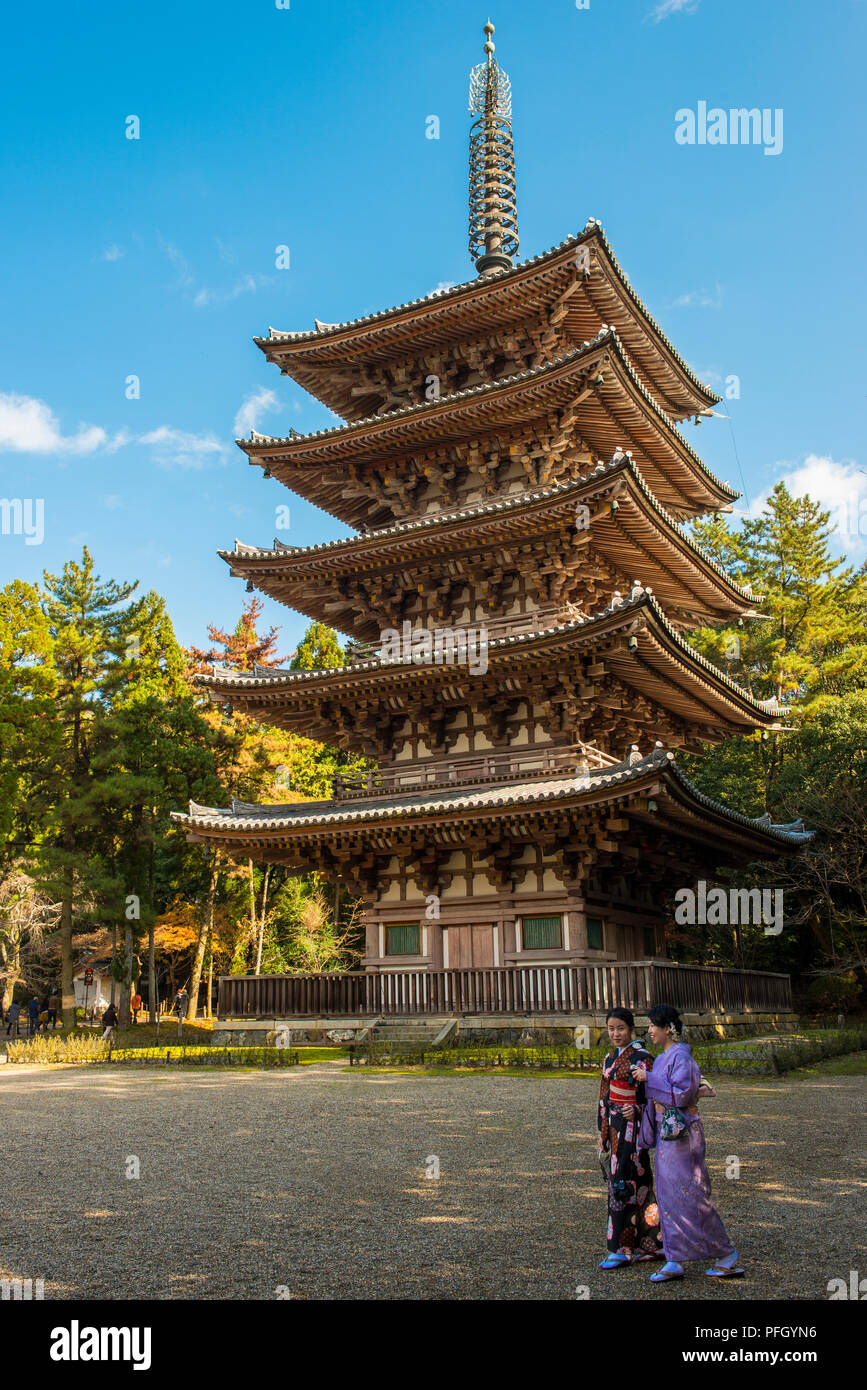 Une paire de femmes japonaises portant des kimonos traditionnels se promonent devant un temple de la ville de Kyoto, au Japon. Banque D'Images