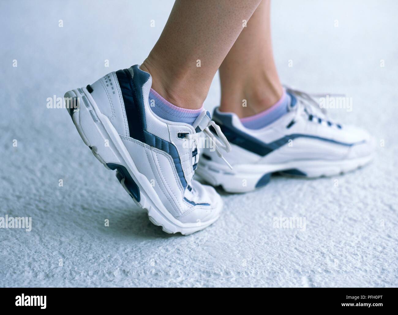 Pieds de femme dans les chaussures de sports, comité permanent sur la bille  de pied avec le pied droit, close-up Photo Stock - Alamy