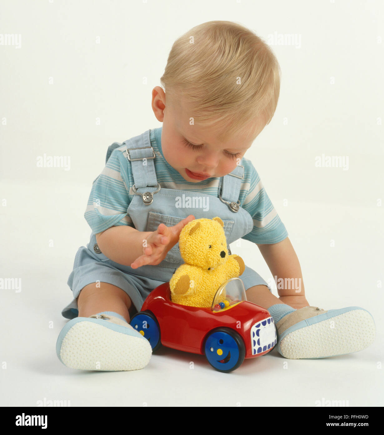 Bebe Garcon Aux Cheveux Blonds En Salopette Bleue Et Chemise Rayee Rouge Assis Avec Voiture Jouet En Plastique Jaune Avec Des Ours En Peluche A L Interieur Entre Les Jambes A La Voiture Bebe Garcon Aux Cheveux Blonds En Salopette Bleue Et Chemise Rayee Rouge Assis Avec Voiture Jouet En Plastique Jaune Avec Des Ours En Peluche A L Interieur Entre Les Jambes A La Voiture