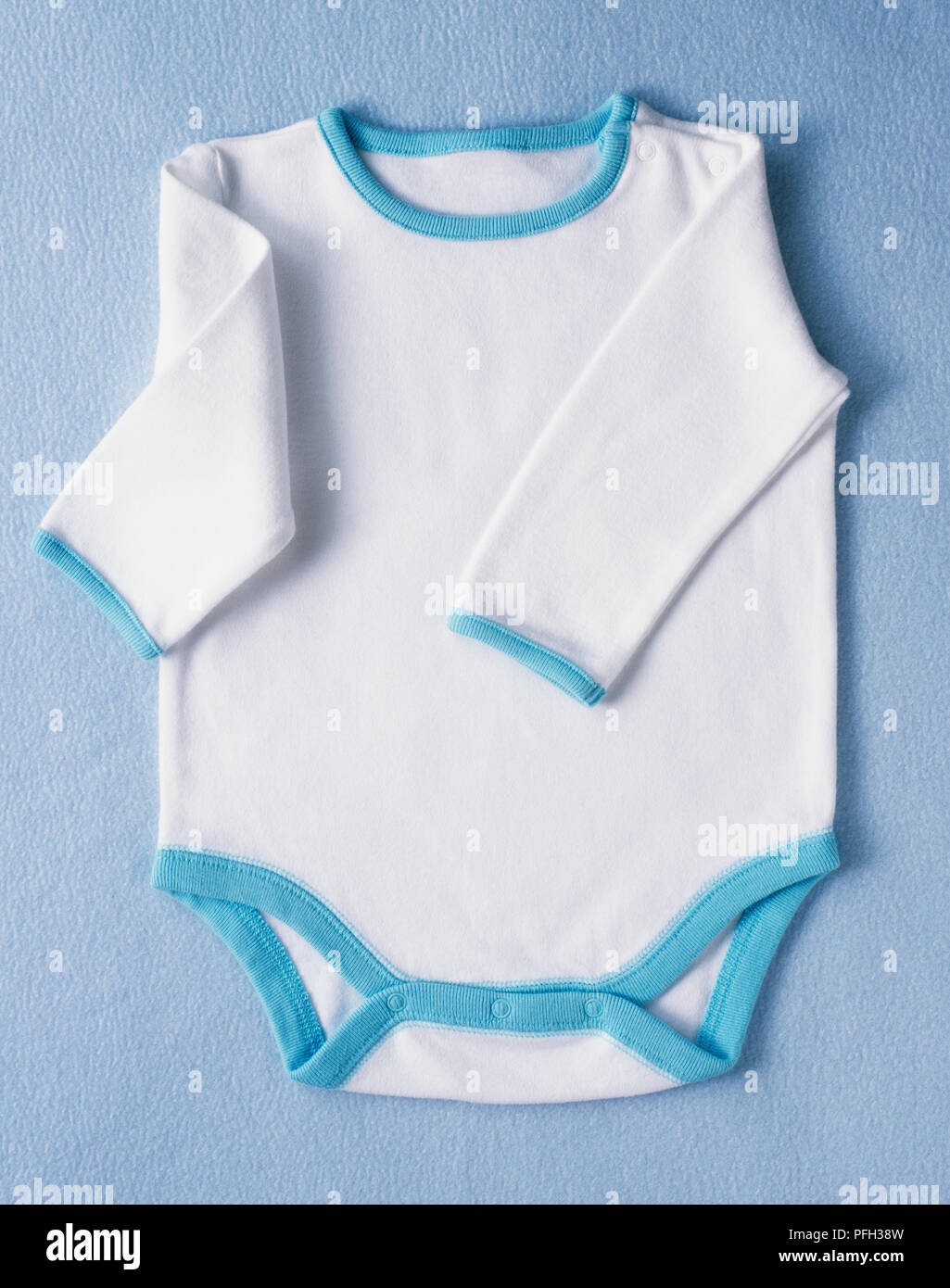 Le livre blanc de bébé l'un complet-veston à manches longues et garniture bleu Banque D'Images