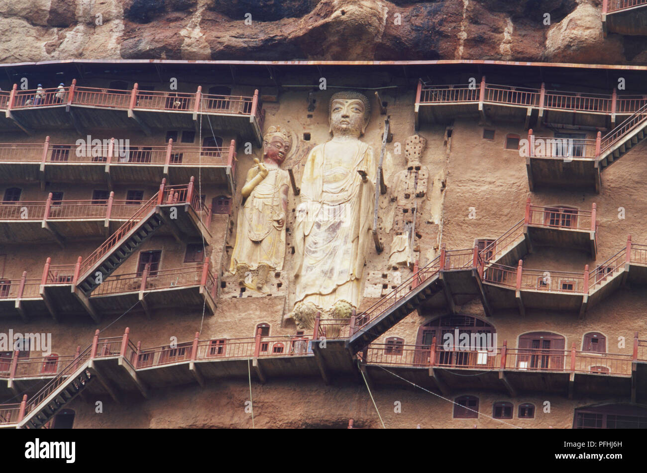 La Chine, au Gansu, Maiji Shan ou maïs Rick Mountain, Cave 98, grande statue de Bouddha Amitabha avec deux Avalokitesvara creusée dans la montagne. Banque D'Images