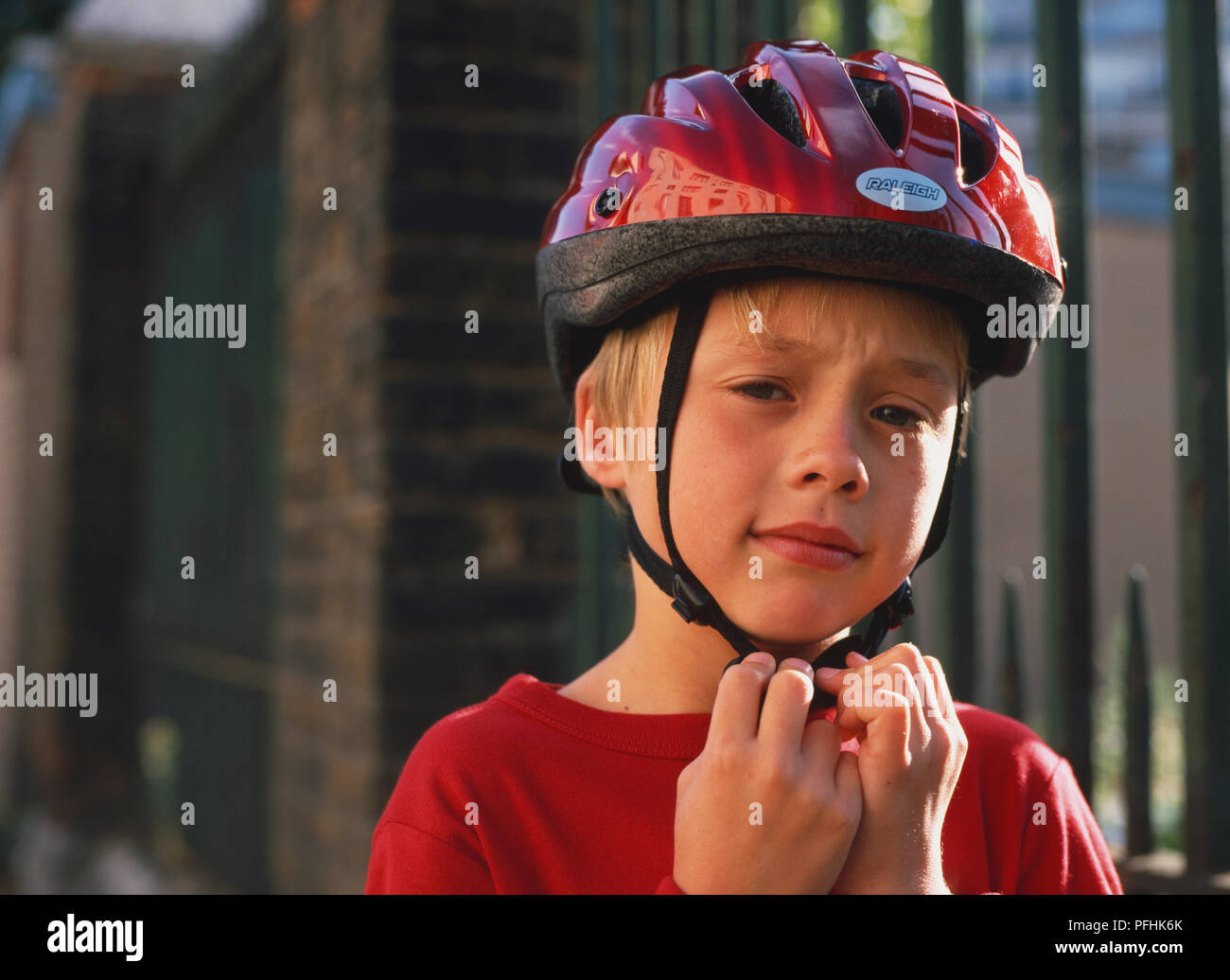 Réglage de garçon son casque de vélo. Banque D'Images