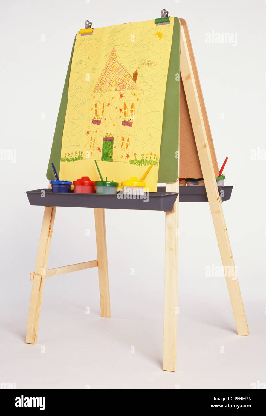 La peinture de l'enfant de chambre avec cheminée sur fumeurs de chevalet, les pots de peinture avec des pinceaux sur bac. Banque D'Images