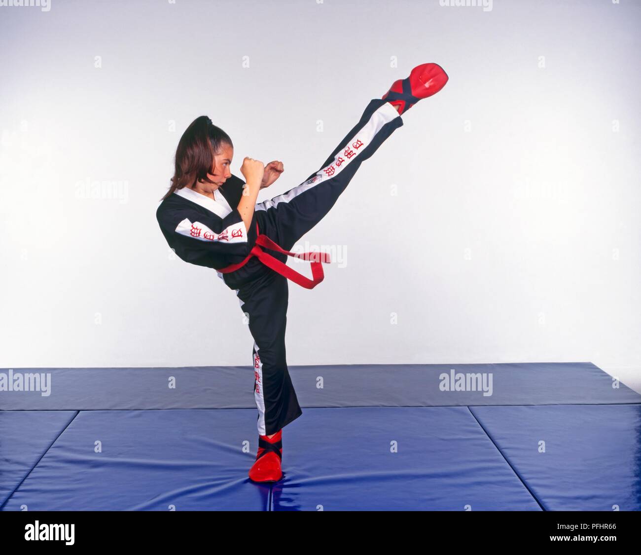 12 ans, effectuant un high kick, art martial appelé Freestyle Banque D'Images