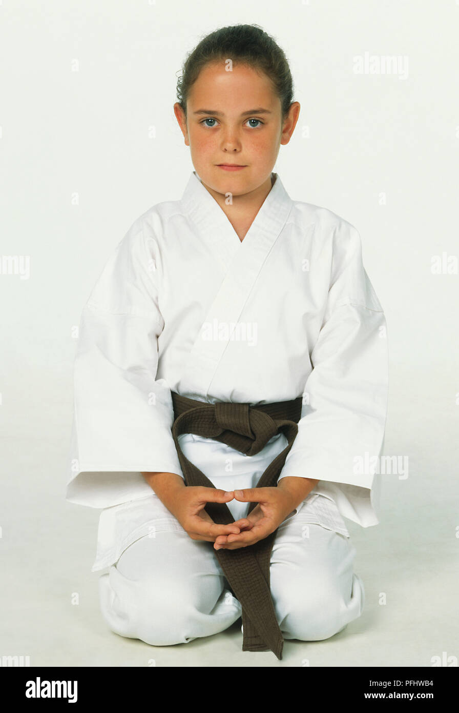Fille de karaté blanc avec ceinture brune à genoux sur le sol avec les  mains sur ses genoux, front view Photo Stock - Alamy