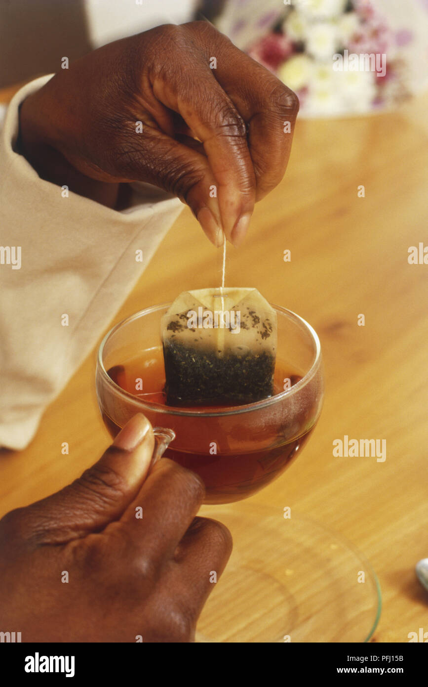 Woman holding herbal tea bag dans un verre Banque D'Images